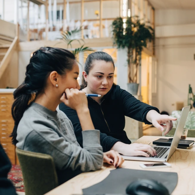 A girl and her mom are discussing each other and browsing a laptop powered by Brightspeed Internet.