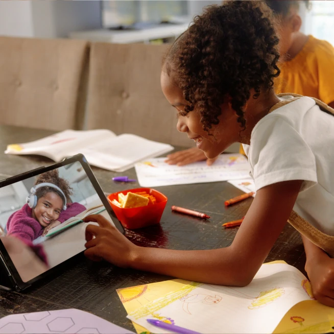 A girl and her friend conncted  video call on tablet , discussing each other.