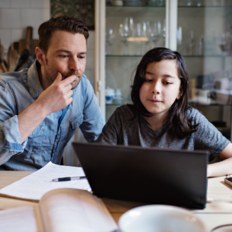 Father and daughter studying together using a laptop