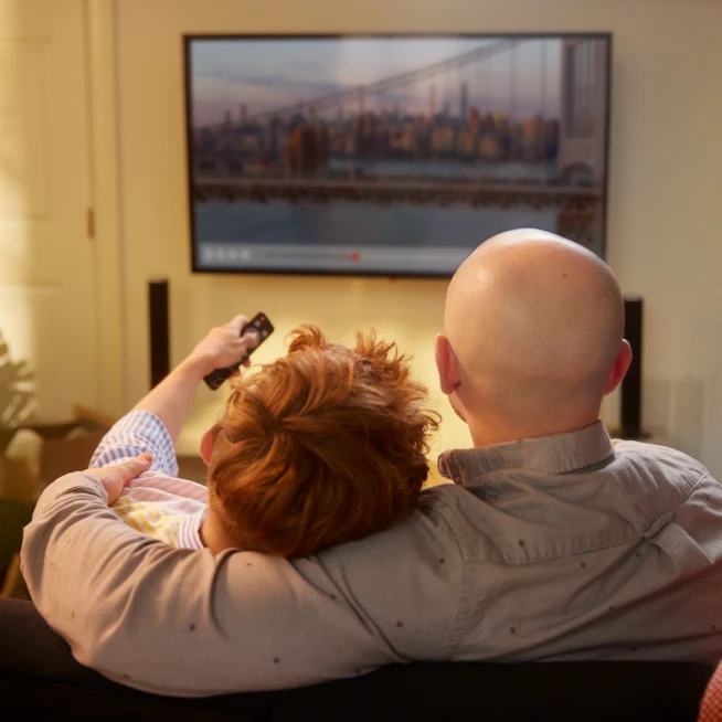 Two people are  watching TV powered by Brightspeed internet.