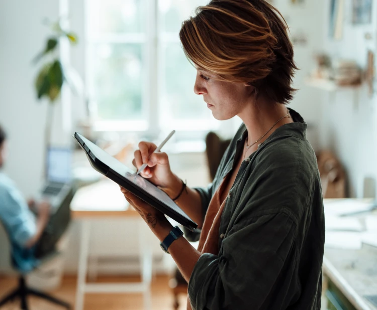 A young lady preparing notes on a Tablet powered by Brightspeed home internet.