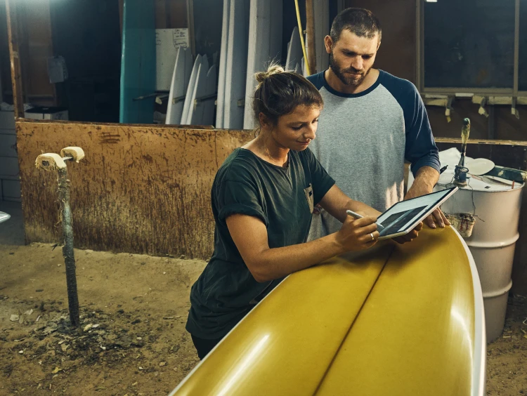 Women and men standing, women browsing tablets, and that man watching it