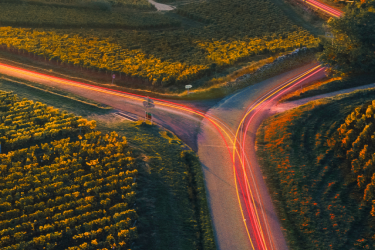 Aerial view of a rural road with car trails