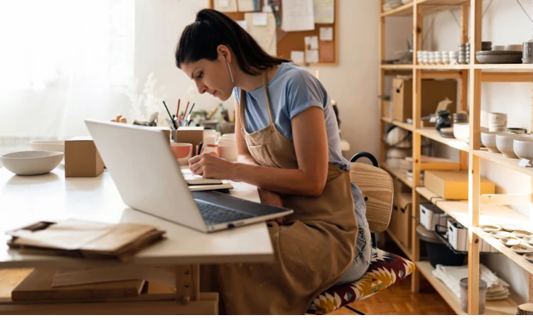 A woman sit infornt of the Laptop and keeping notes connected with Business Internet by Brightspeed.