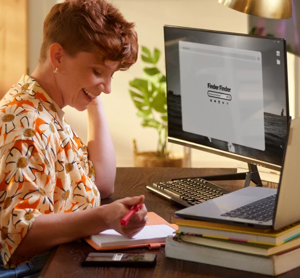 A woman is preparing notes by using multiple devices, like a desktop, laptop, and mobile, connected to Brightspeed Fiber Internet.